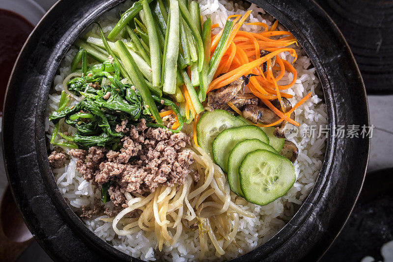 BI Bim Bap，拌菜饭，顶视图与热酱在铸铁锅